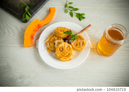 sweet lush pumpkin pancakes with honey in a plate 104810728