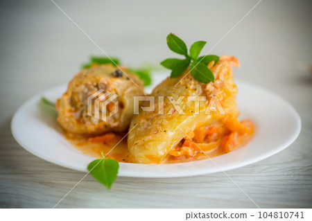 stewed in gravy stuffed peppers in a plate on a wooden table 104810741