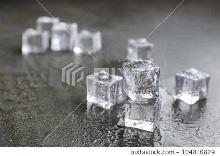 Crystal clear ice cubes on grey stone table. Space for text 104810829