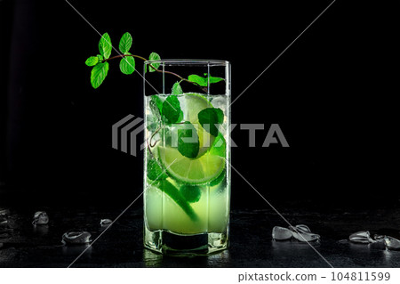 Mojito cocktail. Summer cold drink with lime, fresh mint, and ice. Cool beverage 104811599