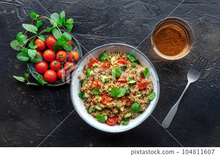 Quinoa tabbouleh salad in a bowl, a healthy dinner with tomatoes and mint Quinoa tabbouleh salad in a bowl, a healthy dinner with tomatoes and mint 104811607
