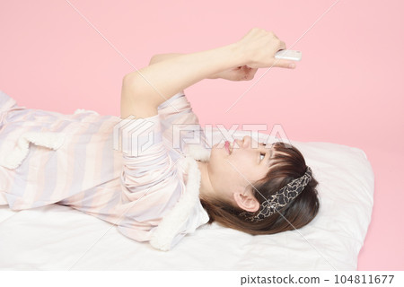 操作智能手機的穿著睡衣的女人 104811677