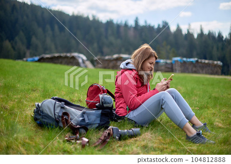 Young tourist girl on the top of the mounting landscape. Hiking woman relaxing. Caucasian beautiful woman wearing casual clothes, adventure traveling alone and hiking on the top of mountains in 104812888