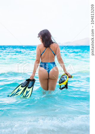 sexy woman in blue swimsuit going to the sea with with flippers and snorkeling mask sexy woman in blue swimsuit going to the sea with with flippers and snorkeling mask 104813209