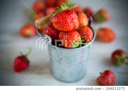 red ripe natural strawberries on a wooden table 104813273