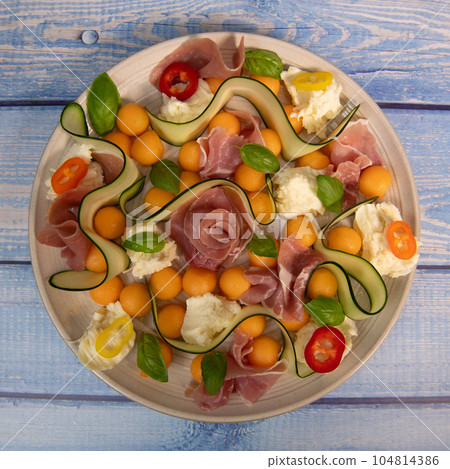 RECIPE FOR MELON, MOZARELLA, BASIL AND CURED HAM SALAD, CUCUMBER SLICE, ORANGE VINAIGRETTE 104814386