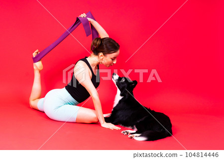 Woman walking and getting exercise for both herself and her border collie dog. 104814446