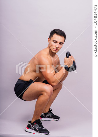 Handsome muscular man holding kettle bell with copy space. Hispanic male athlete Handsome muscular man holding kettle bell with copy space. Hispanic male athlete 104814472
