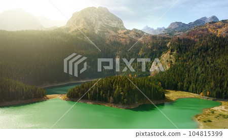 Amazing aerial drone view of Black Lake in National Park Durmitor, Montenegro. Mountain lake landscape on autumn sunset. Amazing aerial drone view of Black Lake in National Park Durmitor, Montenegro. Mountain lake landscape on autumn sunset. 104815399