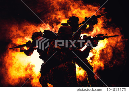 Backlit silhouette of special forces operators fighting in the smoke on fire explosion background. Battle, bombs exploding, they fighting no matter what Backlit silhouette of special forces operators fighting in the smoke on fire explosion background. Battle, bombs exploding, they fighting no matter what 104815575