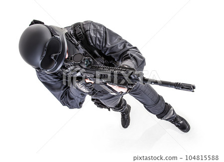 Spec ops police officer SWAT in black uniform aiming service rifle, studio shot, view from above 104815588