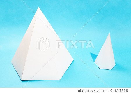 pair of different paper pyramids on turquoise blue pair of different paper pyramids on turquoise blue 104815868