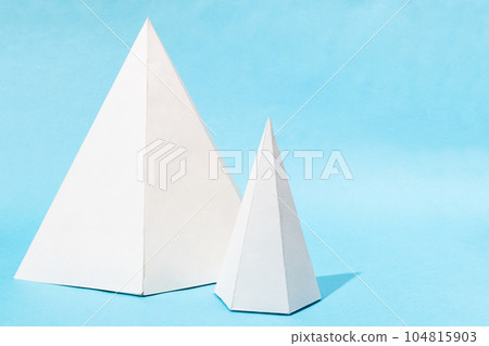 paper big and small lying pyramids on turquoise 104815903