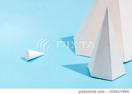 paper pyramids close up and lying cone top on blue 104815904
