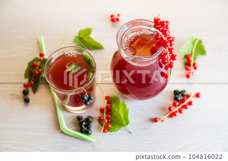 fresh berry juice from red and black currant, on a wooden table 104816022