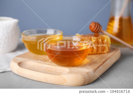 Tasty organic honey on light grey table 104816718