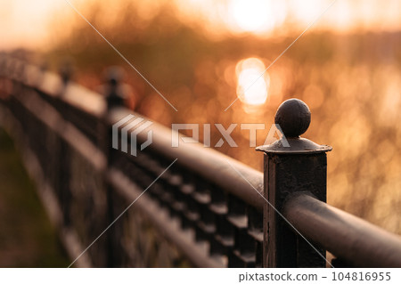 Metal black low fence in the park. Metal black low fence in the park. 104816955