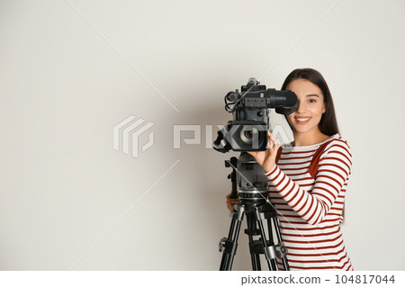 Operator with professional video camera on white background, space for text 104817044