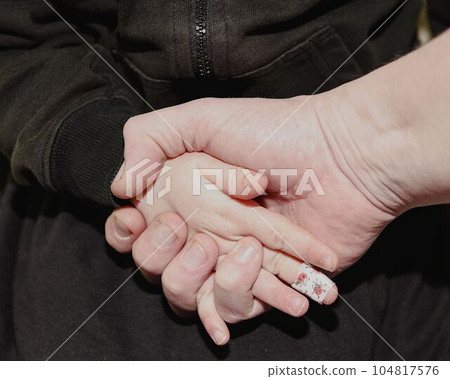 Hand man holding hand girl child. Girl child with sticking plaster on finger. Concept idea. Family and father concept. Hand man holding hand girl child. Girl child with sticking plaster on finger. Concept idea. Family and father concept. 104817576