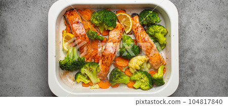 Top view of healthy baked fish salmon steaks, broccoli, cauliflower, carrot in casserole dish. Cooking a delicious low carb dinner, healthy nutrition concept Top view of healthy baked fish salmon steaks, broccoli, cauliflower, carrot in casserole dish. Cooking a delicious low carb dinner, healthy nutrition concept 104817840