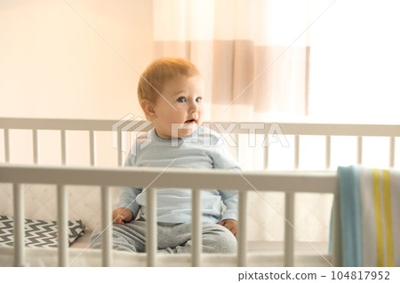 Cute little baby in crib at home Cute little baby in crib at home 104817952