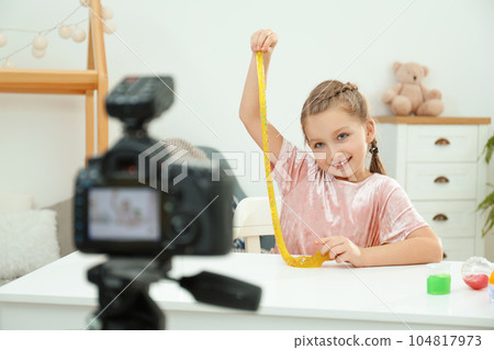 Cute little blogger with slime recording video at home 104817973