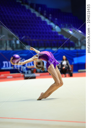 girl gymnast performs an exercise with a ball 104818435
