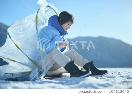 一名二十多歲的婦女在冬季湖中捕魚胡瓜魚 104818640