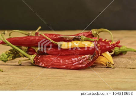 Shrinking and mould chili peppers on wooden background. Rotten chili peppers. Close-up 104818698