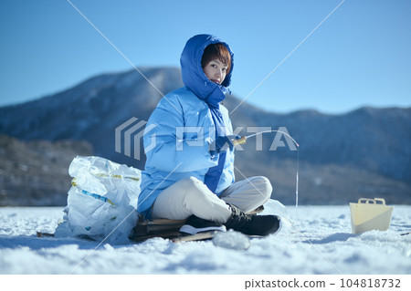 A woman in her twenties fishing for smelt in a winter lake A woman in her twenties fishing for smelt in a winter lake 104818732