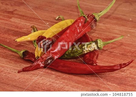 Shrinking and mould chili peppers on red wooden background. Rotten chili peppers Shrinking and mould chili peppers on red wooden background. Rotten chili peppers 104818755