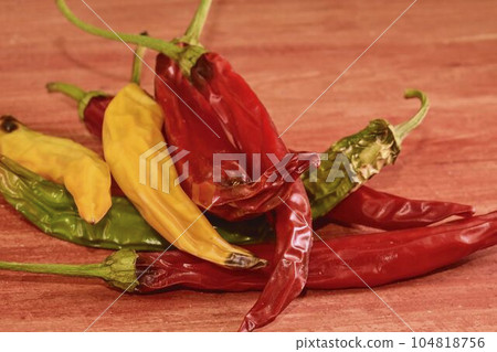 Shrinking and mould chili peppers on red wooden background. Rotten chili peppers Shrinking and mould chili peppers on red wooden background. Rotten chili peppers 104818756