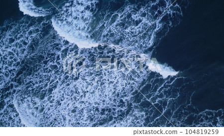 Aerial view of arctic ocean shore with black sand beaches, nordic skyline landscape. Beautiful atlantic coastline scenery in iceland with snowy mountains and icelandic weather. Slow motion. 104819259