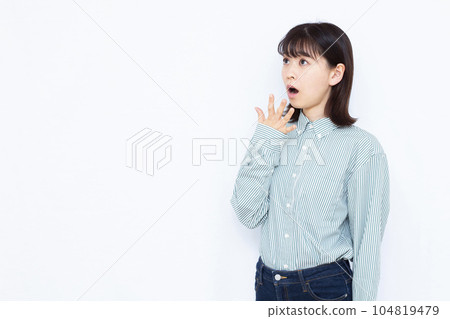 A woman in her thirties who is surprised in front of a white background 104819479