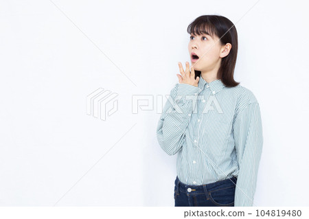 A woman in her thirties who is surprised in front of a white background 104819480