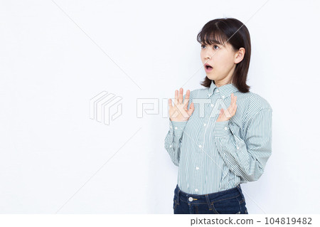 A woman in her thirties who is surprised in front of a white background 104819482