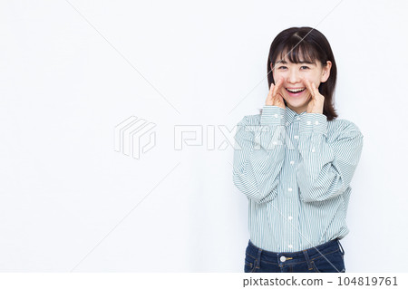 A woman in her thirties screaming with a smile in front of a white background 104819761