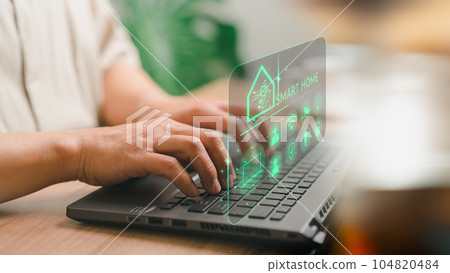 Adult man controlling technology AI smart home devices using a laptop computer with launched application in the bed room. Iot smart home automation app concept. 104820484