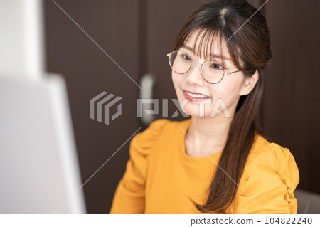 一名 20 多歲的女士戴著眼鏡進行遠程辦公 一名 20 多歲的女士戴著眼鏡進行遠程辦公 104822240