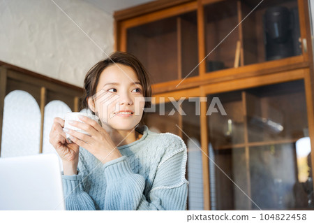 Woman drinking coffee and watching computer 104822458
