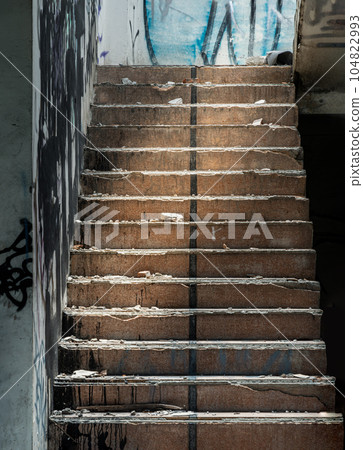 The old cement staircase and the graffiti patterns on cement wall is in the abandoned building and was left to deteriorate over years. The old cement staircase and the graffiti patterns on cement wall is in the abandoned building and was left to deteriorate over years. 104822993
