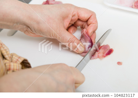 [Housewife preparing yakitori gizzards with a knife] 104823117