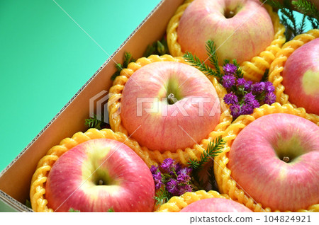 beautiful pink apple in the box on green background beautiful pink apple in the box on green background 104824921