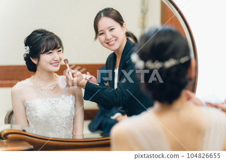 A bridal hair and makeup artist woman (cheek) who does makeup for the bride and groom in the bride's room and waiting room 104826655