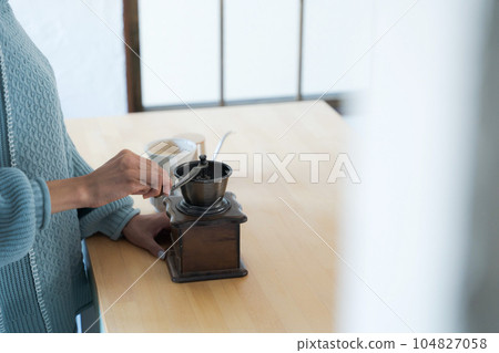 Photo of a woman grinding coffee beans Photo of a woman grinding coffee beans 104827058