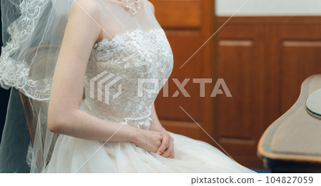 A bride and a bride wearing a wedding dress preparing for a wedding ceremony and reception in the bride's room and waiting room A bride and a bride wearing a wedding dress preparing for a wedding ceremony and reception in the bride's room and waiting room 104827059