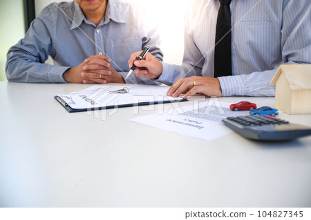 Sales manager giving advice application form document, considering mortgage loan offer for car and house insurance. Sales manager giving advice application form document, considering mortgage loan offer for car and house insurance. 104827345