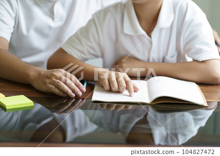 Asian father helps son to do her homework for the school..child study together homeschooling concept getting homework help from father 104827472