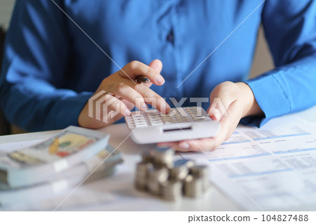 Business woman calculating financial statement on calculator income tax online return and payment. Business woman calculating financial statement on calculator income tax online return and payment. 104827488