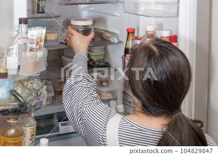 [A housewife takes out a pickled plum from the refrigerator] 104829847